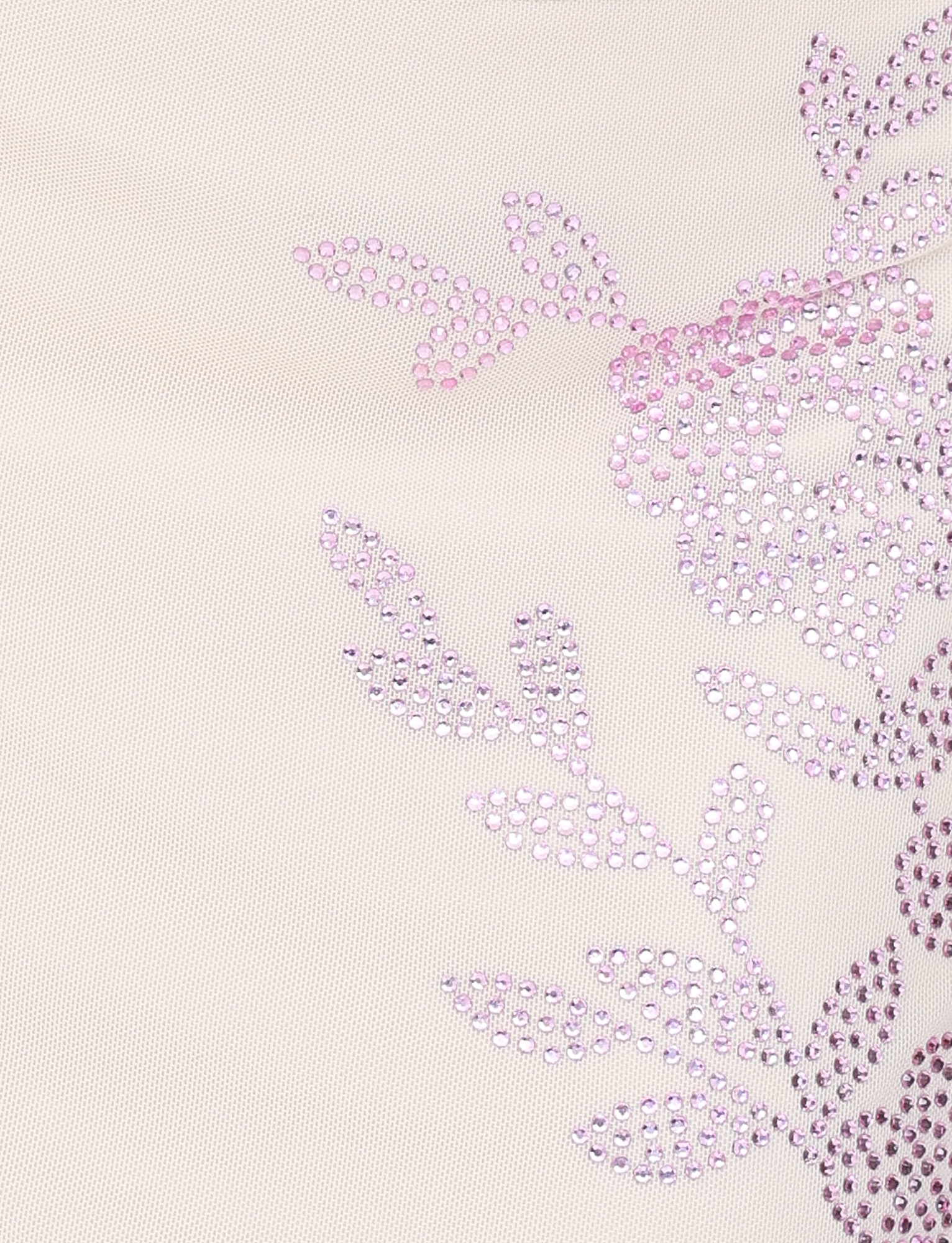Close-up of the TIGERMIST OCTAVIA MINI SKIRT in cream, featuring light beige fabric with a decorative floral pattern of shiny pink rhinestones forming flowers and leaves on the right side.