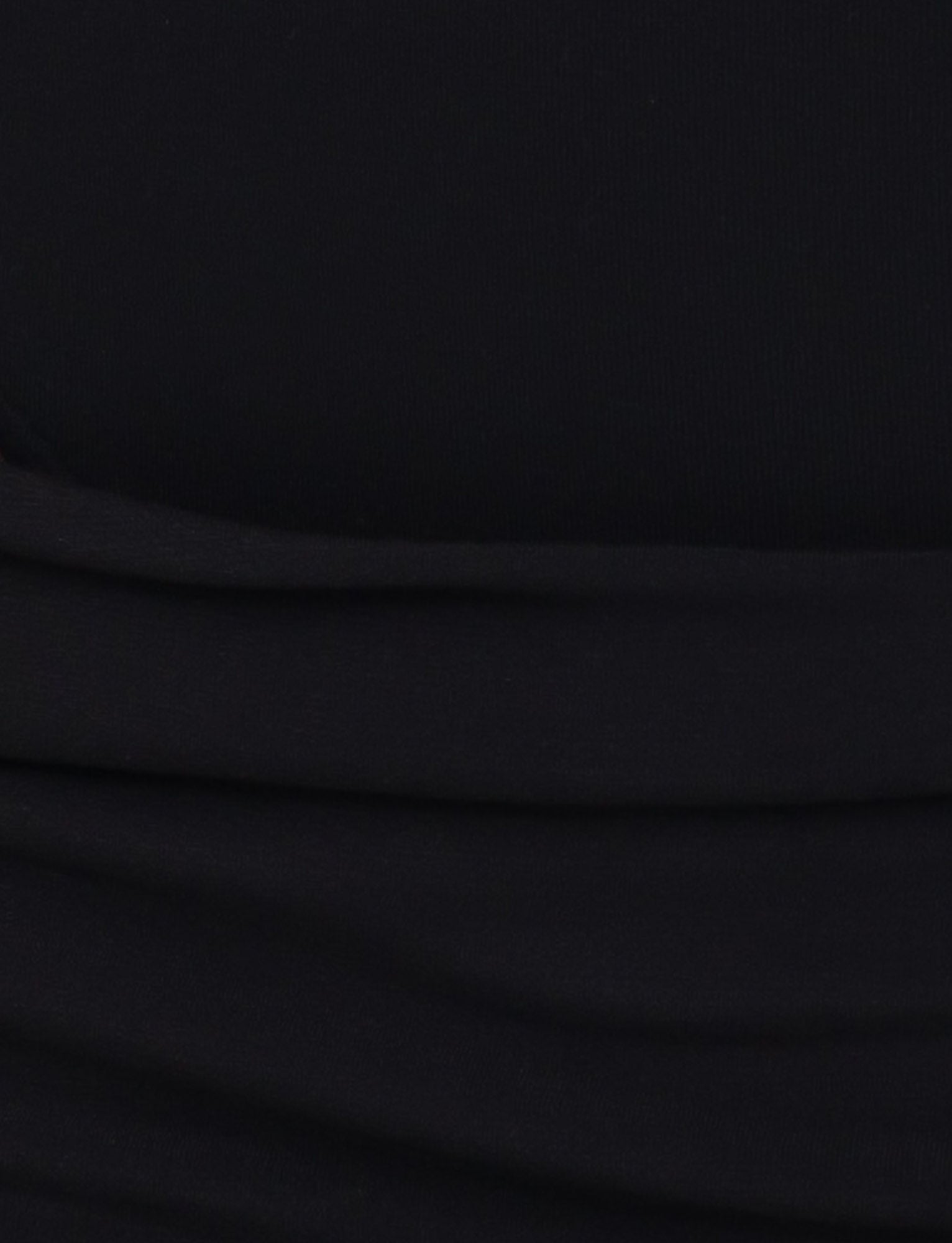 A close-up of the UMA DRESS - BLACK by TIGERMIST, highlighting its soft black fabric with horizontal folds and gentle drape—ideal for a chic maxi or sleek bodycon look.