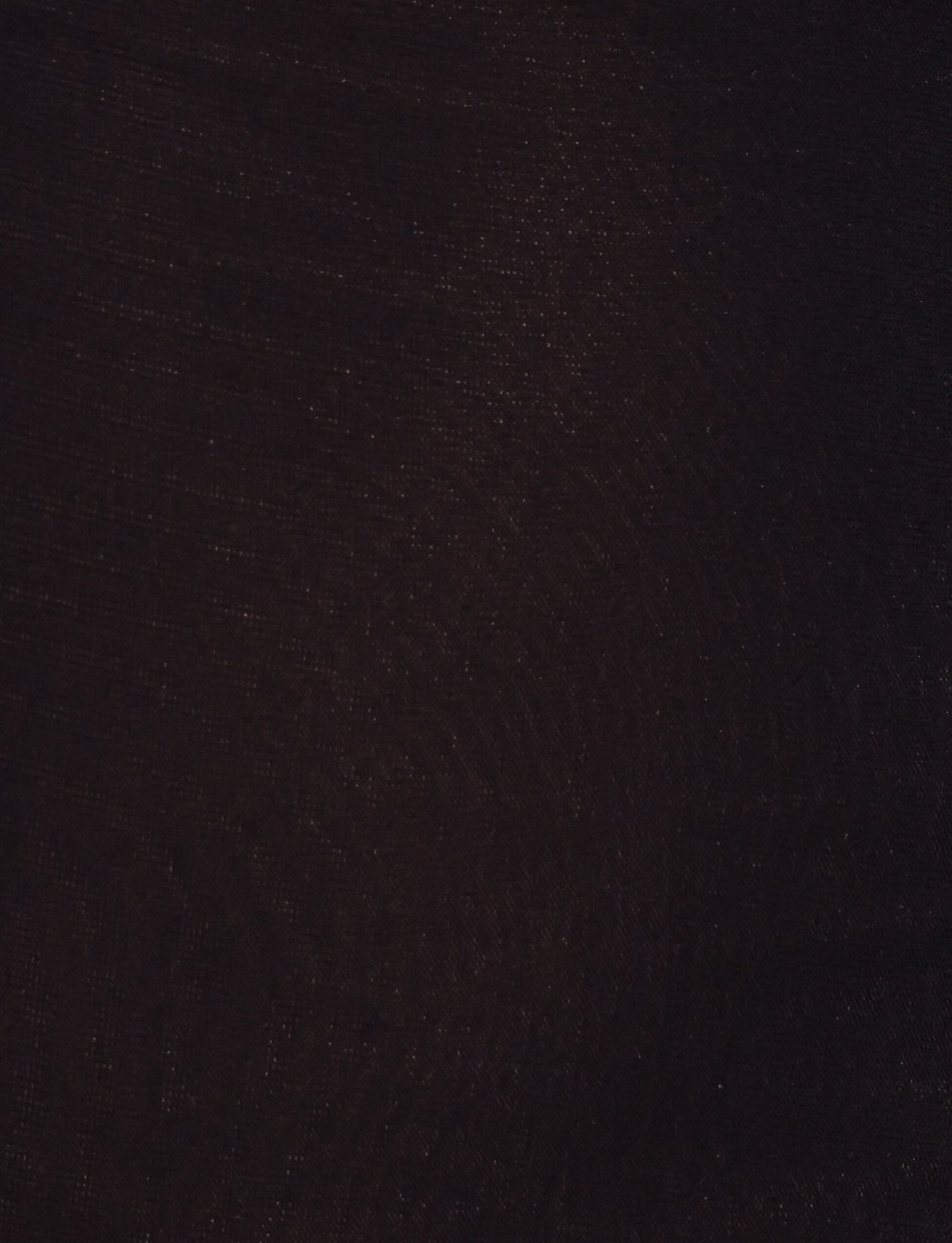A close-up of the dark textured fabric of the TIGERMIST FREYA DRESS - BLACK reveals subtle weave patterns and a gentle sheen—ideal for a buttery soft mini dress with an adjustable asymmetrical neckline.