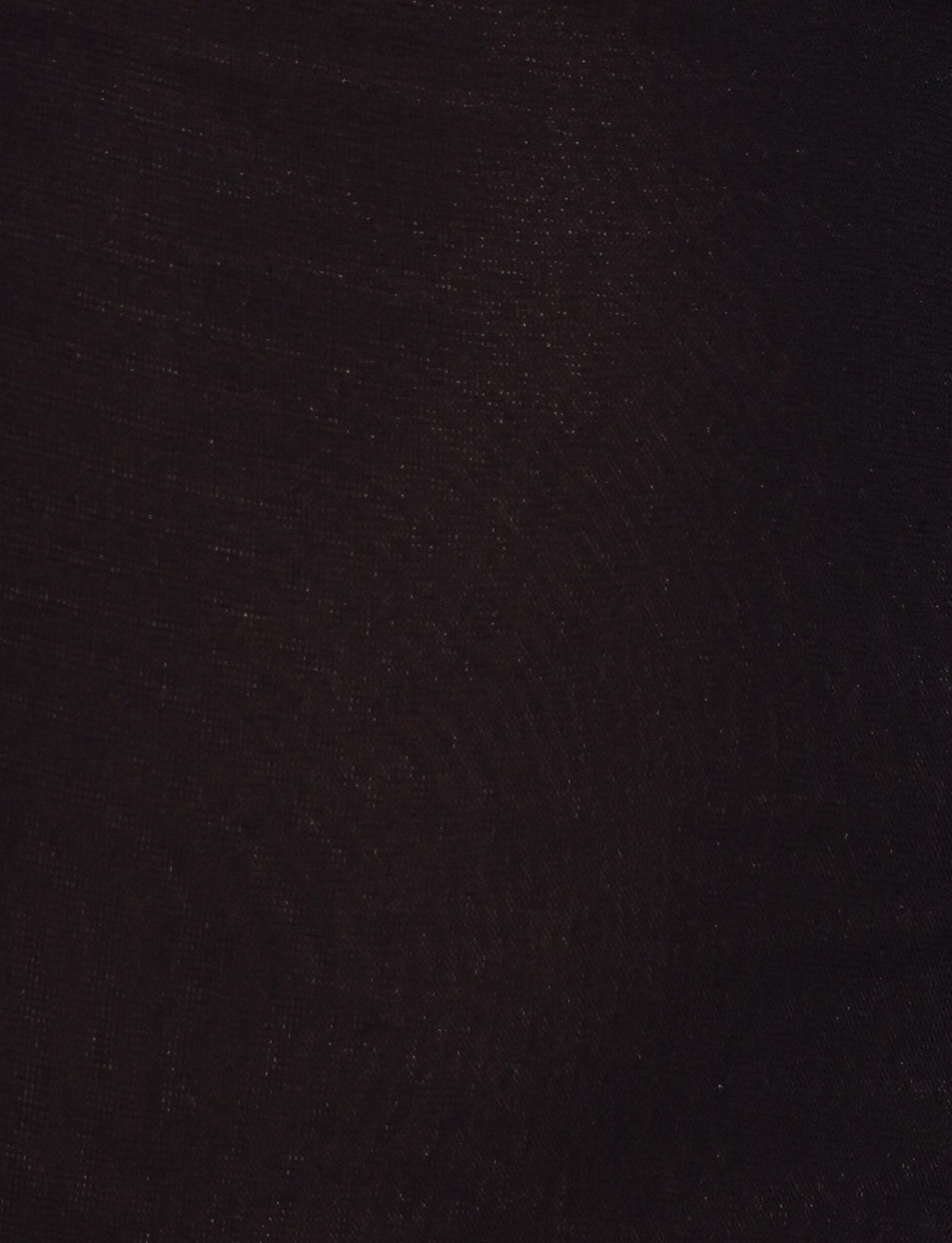 A close-up of the dark textured fabric of the TIGERMIST FREYA DRESS - BLACK reveals subtle weave patterns and a gentle sheen—ideal for a buttery soft mini dress with an adjustable asymmetrical neckline.