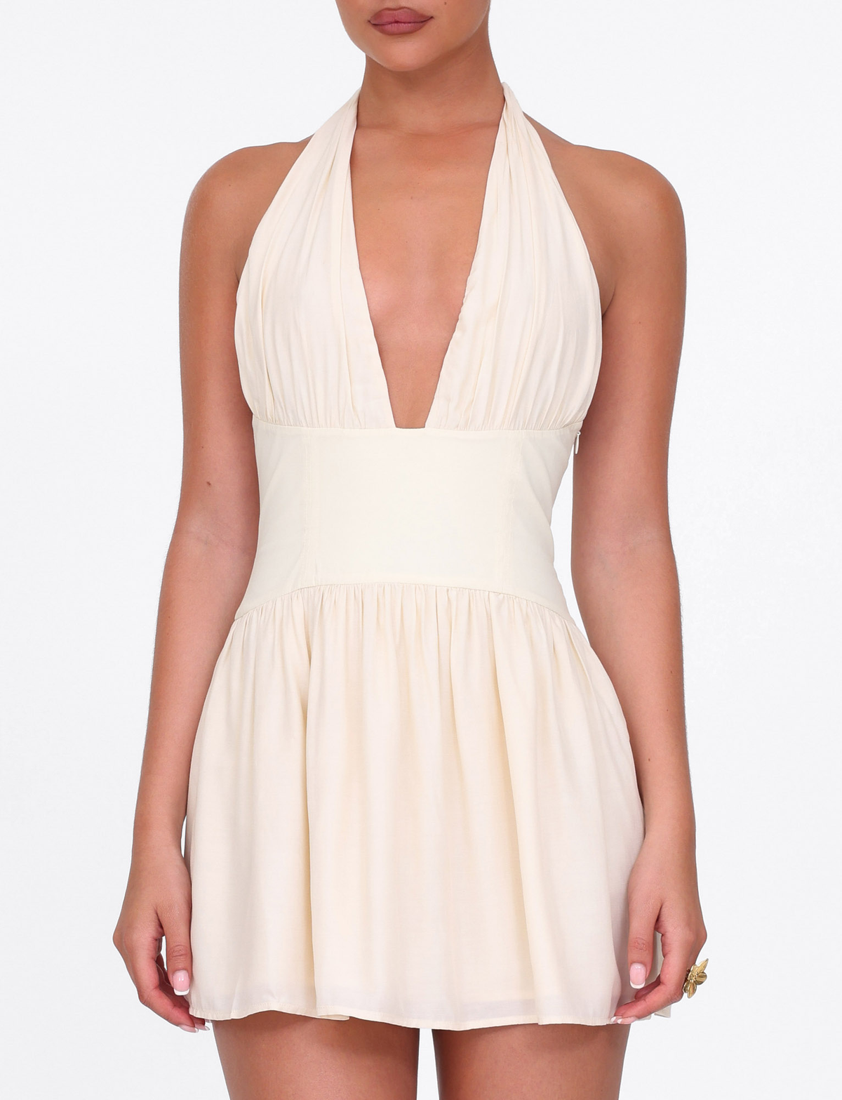 Woman models the TIGERMIST CALISTA MINI DRESS in yellow butter, a sleeveless halter mini dress with a plunging neckline and fitted waist panel, standing against a plain white background.