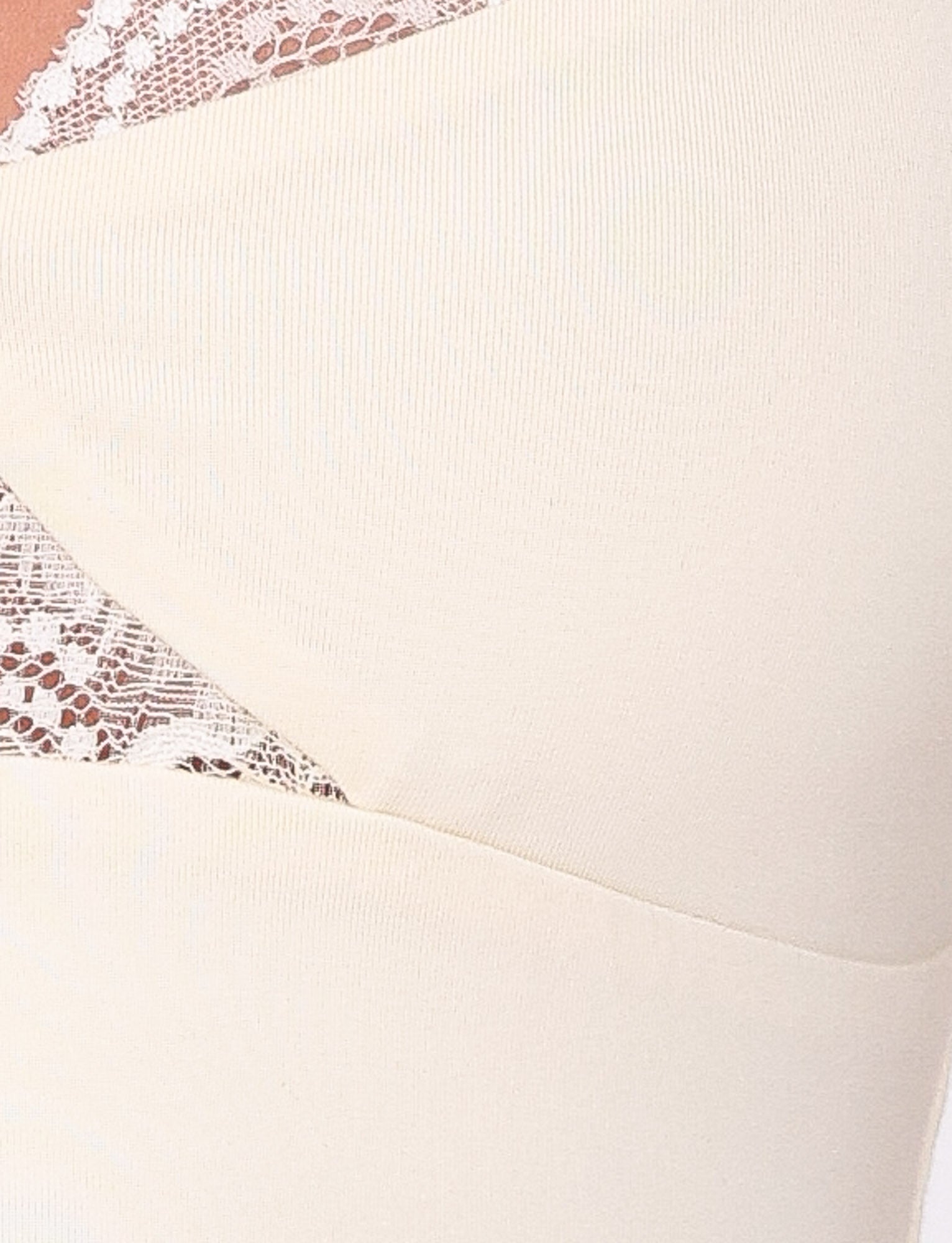 Close-up of the TIGERMIST DIONE LACE TOP in yellow, highlighting its delicate lace trim and cross-over design. The butter jersey fabric appears smooth, while the lace provides a decorative touch, focusing on where the materials intersect.