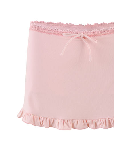 The TIGERMIST MIRELLE SKORT in pastel pink features a lace-trimmed waistband, a delicate front bow, and a ruffled hem.