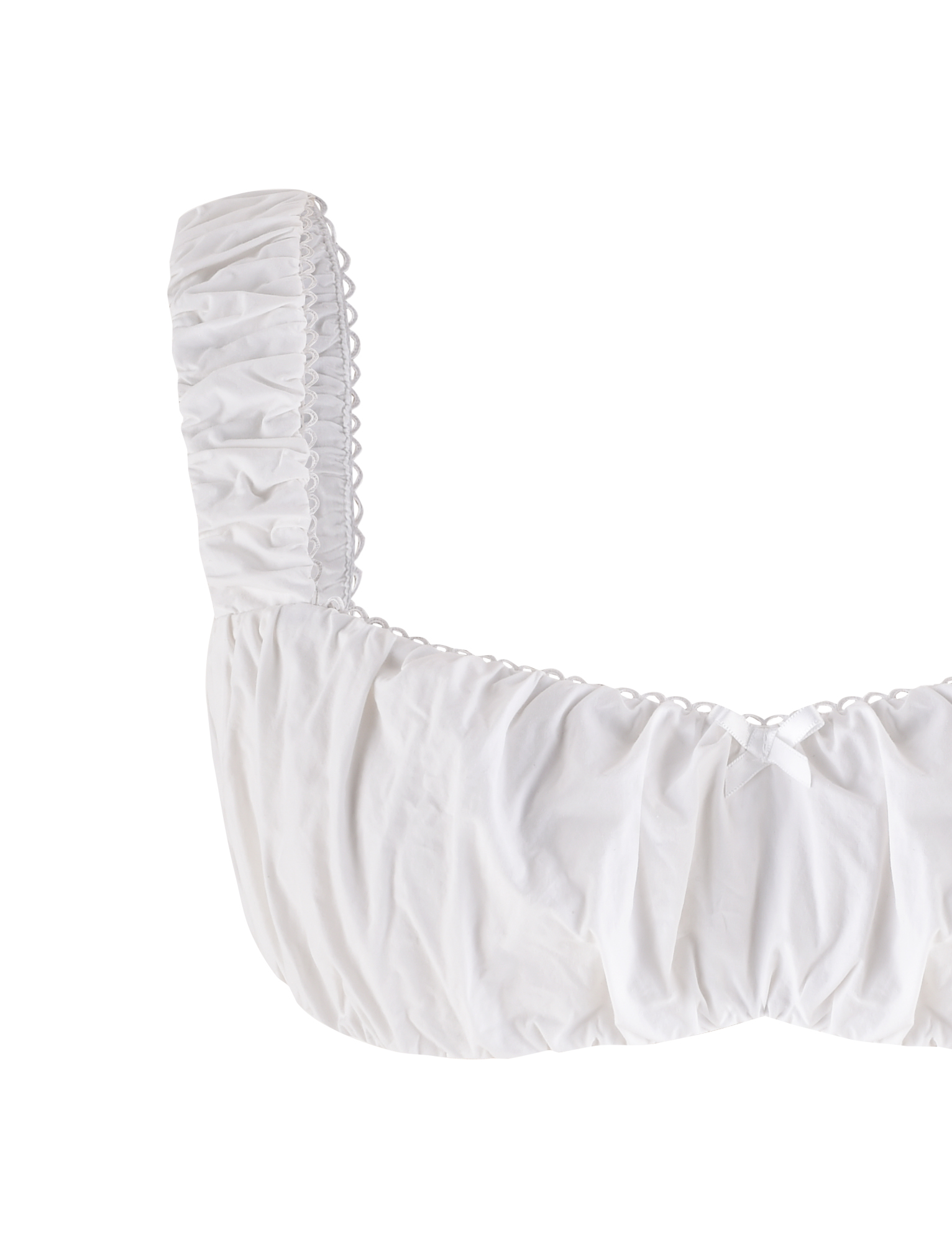 The SABRA TOP - WHITE by TIGERMIST is a cotton cropped top with ruched fabric, wide gathered straps, and a small bow at the neckline, shown on a plain white background.