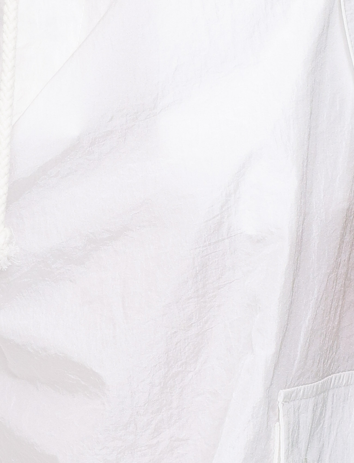 Close-up of the TIGERMIST VIOLETTE PANT - WHITE, featuring textured nylon fabric, visible seam and pocket detailing, a thick white drawstring on the left, and oversized crinkled folds highlighted by lighting.