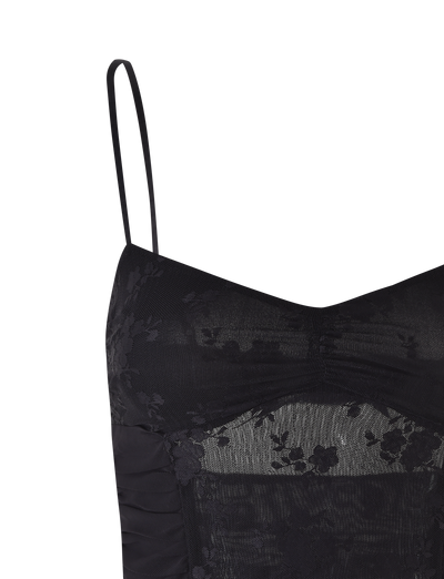 A close-up of the KALLIE TOP - BLACK by TIGERMIST, showcasing mesh panels, thin adjustable straps, and sheer floral lace detailing on the bust and upper torso.