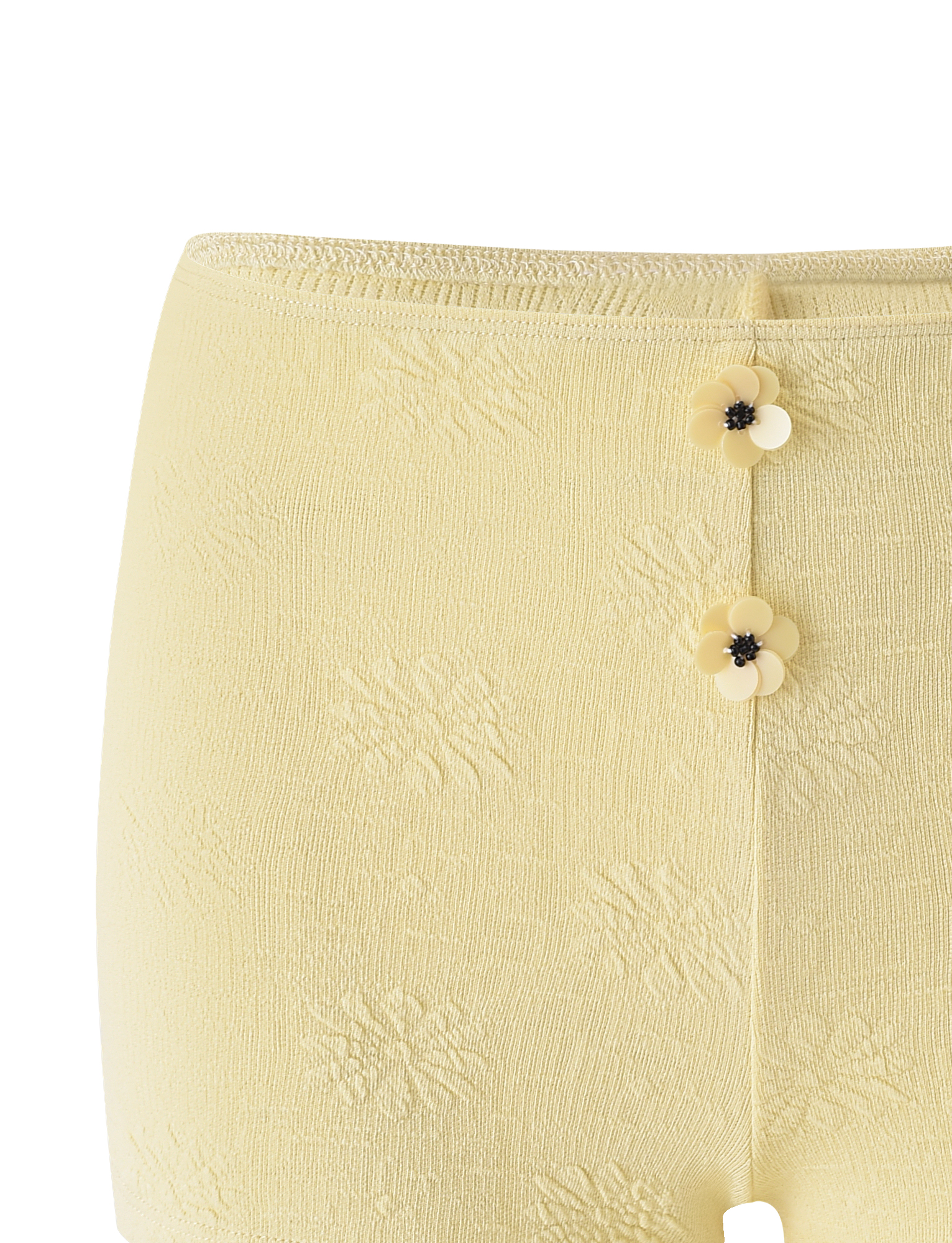 The TIGERMIST QUINLAN SHORT - LEMON features a light yellow hue, two front flower-shaped buttons, a subtle woven floral pattern, and charming flower accents.