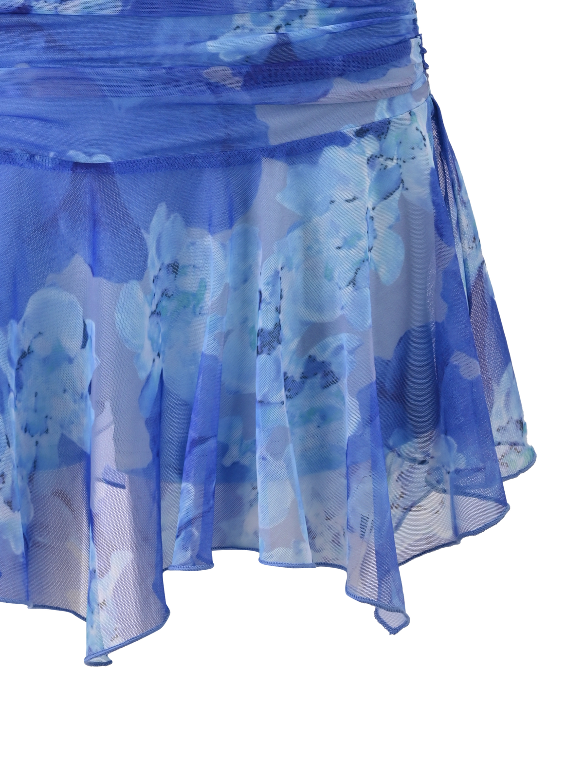 A close-up of the DEVYN MINI SKORT - BLUE MACRO FLORAL by TIGERMIST, featuring sheer, flowy fabric, an asymmetrical hemline, and a mid rise fit with light blue and white floral patterns for a fresh look.