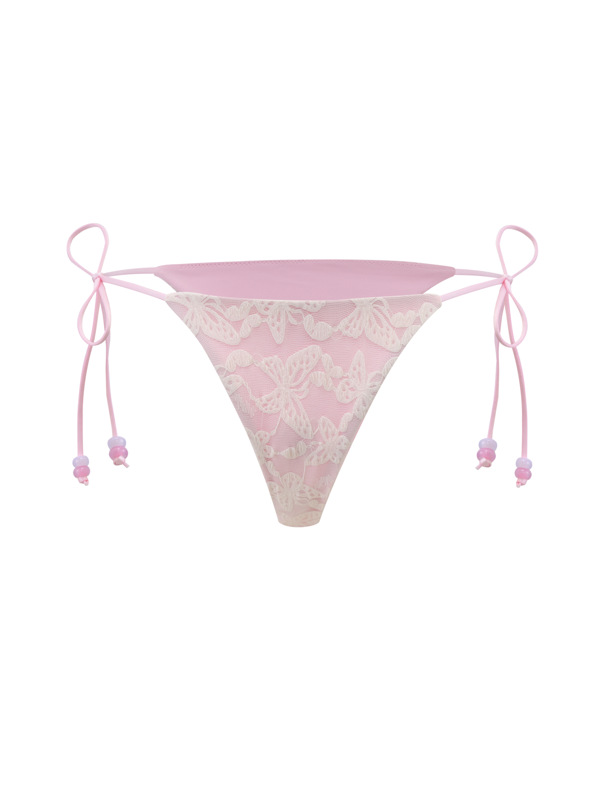 The BRIGITTE BIKINI BOTTOM by TIGERMIST features ivory lace with a cheeky bikini cut, side ties, and delicate ribbon bows, shown against a light pink background.