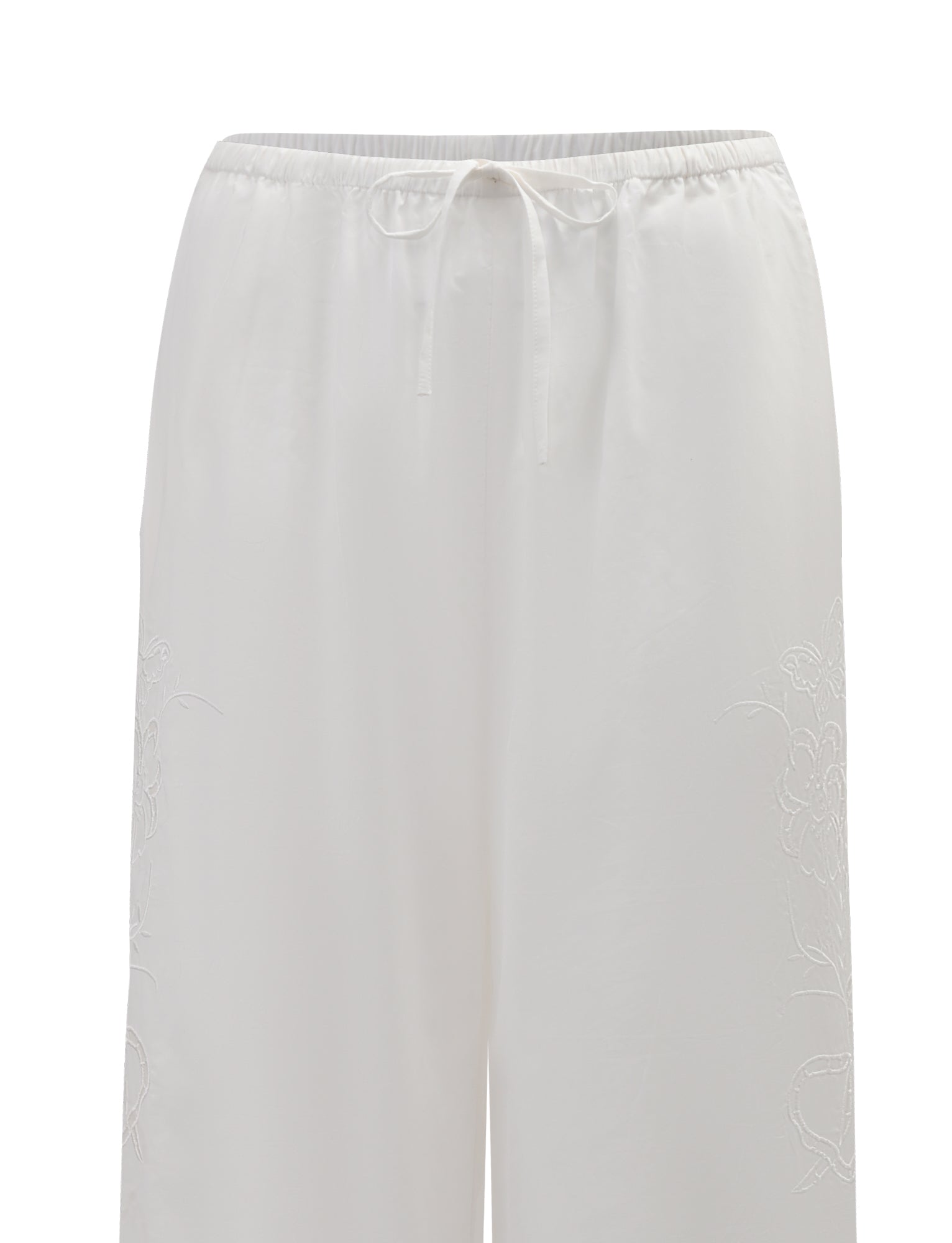 The CRESSY PANT - WHITE by TIGERMIST features a wide-leg, full-length cotton design with an elastic waistband and drawstring, soft lightweight fabric, and subtle floral embroidery along the sides.