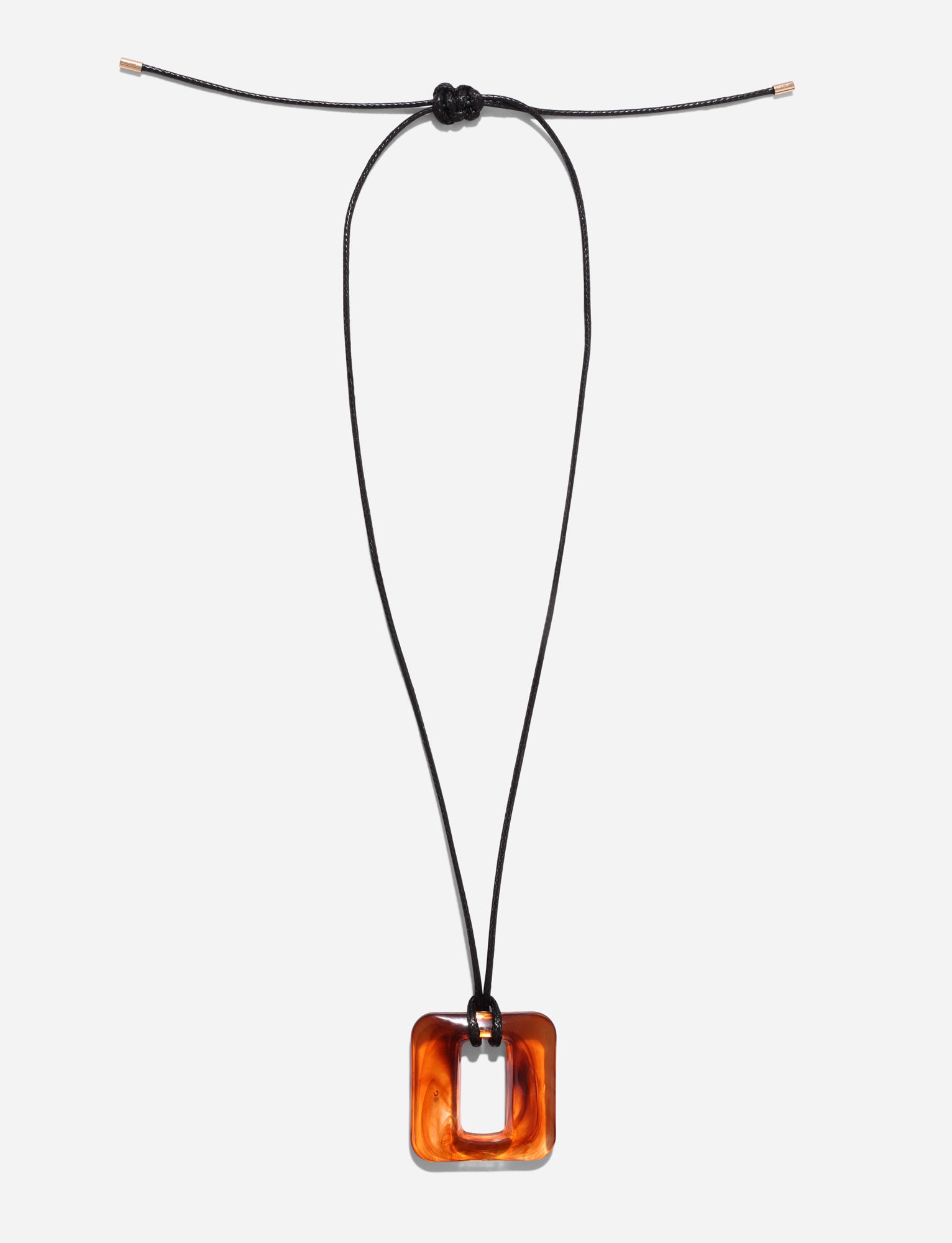 The MIRREN SQUARE NECKLACE - BROWN by TIGERMIST features a minimalist design with a glossy tortoiseshell rectangular pendant on a black woven cord, adjustable with metal tips. Displayed elegantly on a white background, it combines resin hardware with refined simplicity.