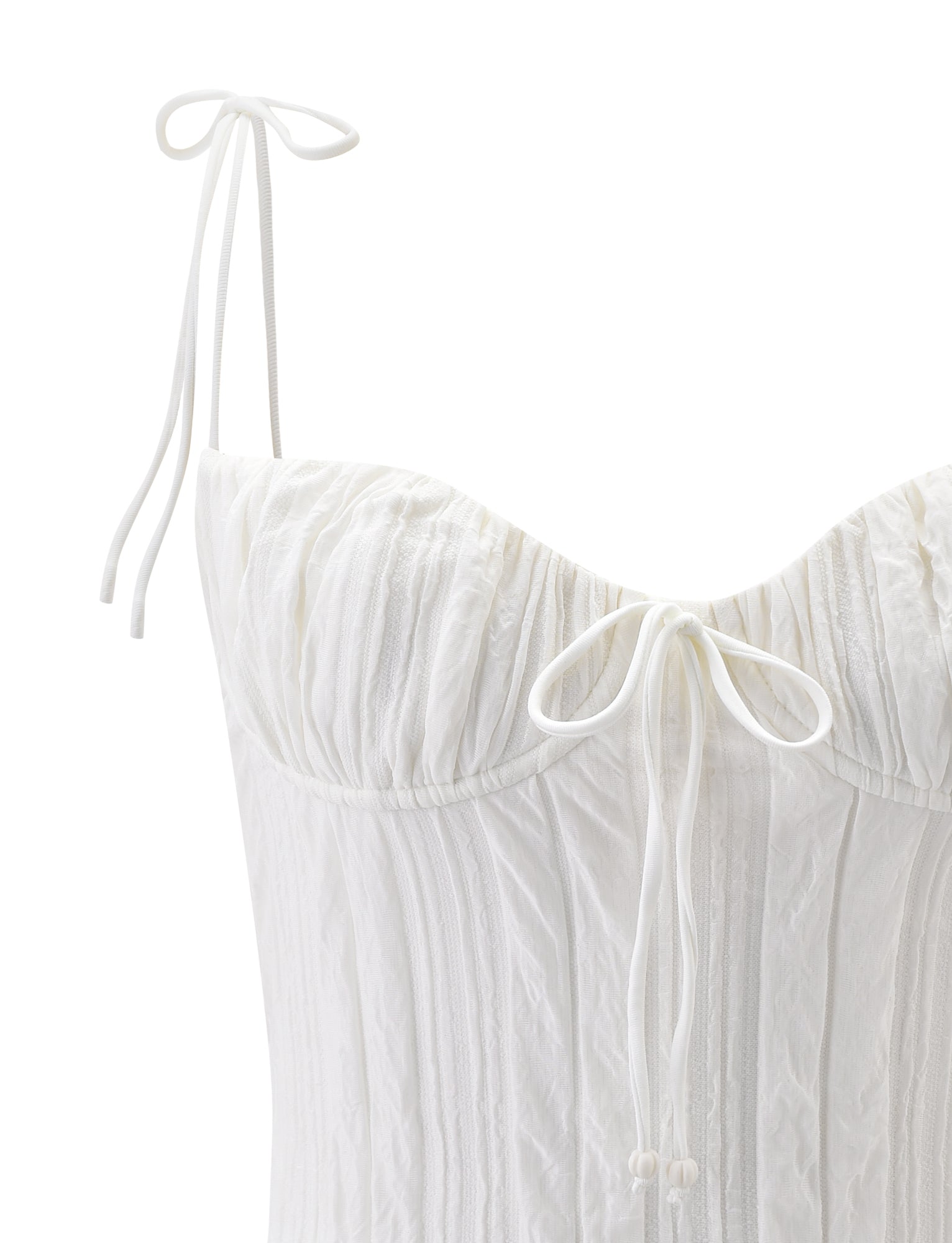 The TIGERMIST RANIA TOP in off-white is a textured bustier featuring a sweetheart neckline, thin strappy shoulder straps tied in bows, a center decorative bow, and a ruched bodice.