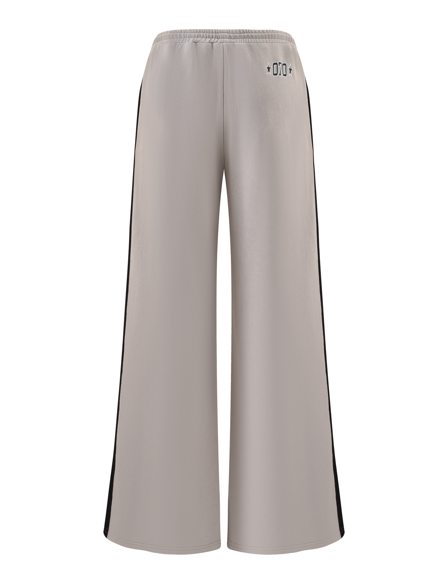 The PAYTON TRACKPANT - STONE by TIGERMIST features a wide-leg fit, taupe cotton fabric, elastic waistband, black side panels, and small black symbols near the back waist. The sporty pants are shown against a white background.