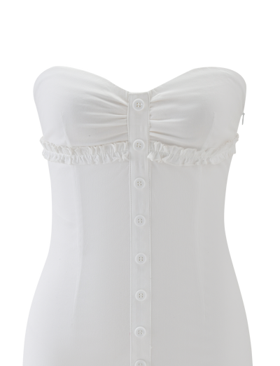 The KITTIE STRAPLESS DRESS - WHITE by TIGERMIST is a strapless mini dress featuring a cinched silhouette, ruched bust, ruffled under-bust trim, and a central row of white buttons down the front.