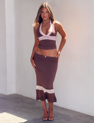 A person wearing a brown halter top with pink lace trim and a matching CALINA LACE PANEL MIDI SKIRT - CHOCOLATE with a pink lace hem.