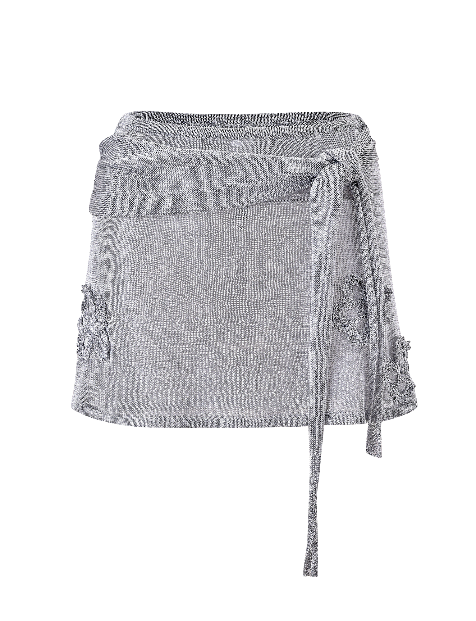 The TIGERMIST ISATANA MINI SKIRT - SILVER is a light gray, semi-sheer mini skirt featuring a wraparound waist tie and floral appliqué details on the sides, shown against a plain white background.
