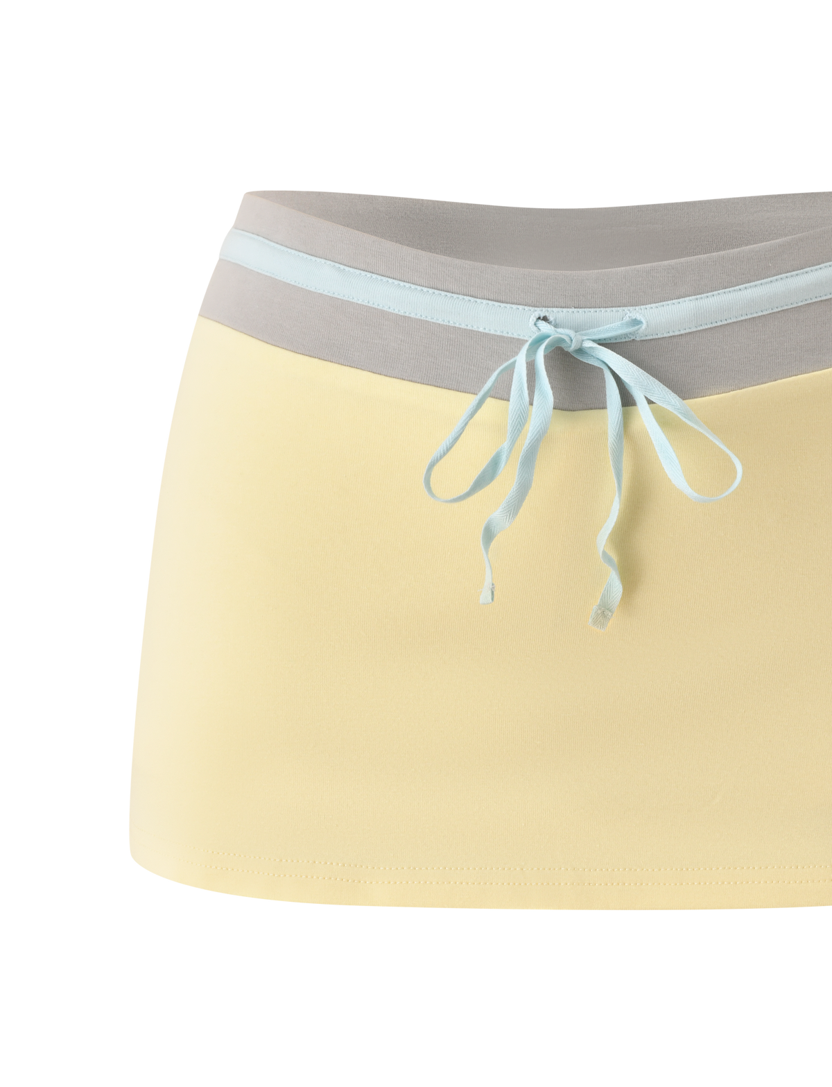 The TIGERMIST COLLINS SKORT - BUTTER features a pale yellow body, light gray wide waistband, and light blue ribbon tie, blending the playful look of a mini skirt with the comfort of mini shorts.