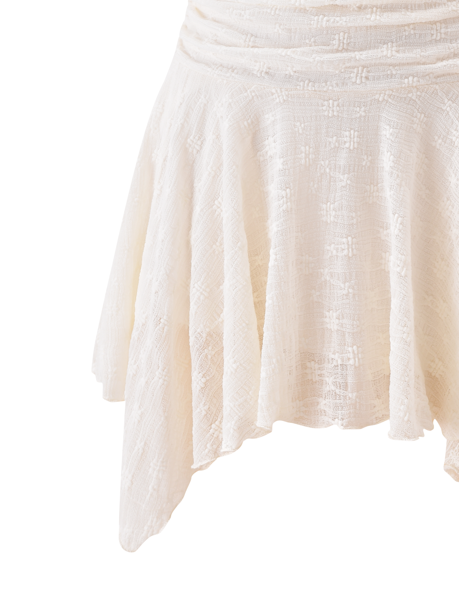 A close-up of the TIGERMIST MYLAH MINI SKIRT in ivory, showcasing its eyelet lace details, textured lightweight fabric, and handkerchief hem, set against a white background.