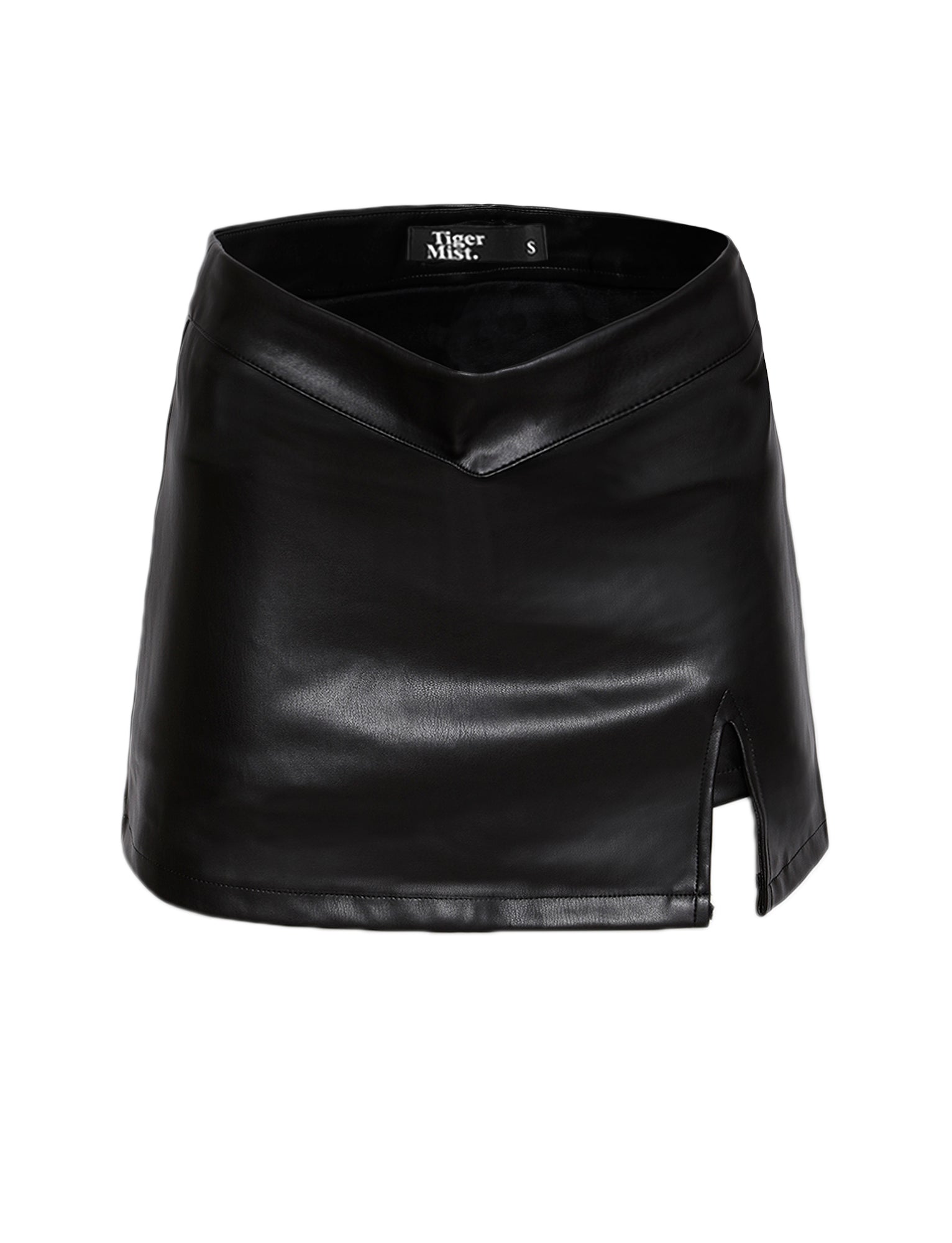 This chic skort from TIGERMIST, named the DAPHNIE PU SKORT – BLACK, features a high waistline and a small front slit on the right side. The waistband has a subtle pointed V-shape at the front, adding to its stylish design. Inside, the label reads "Tiger Mist" with the size "S.