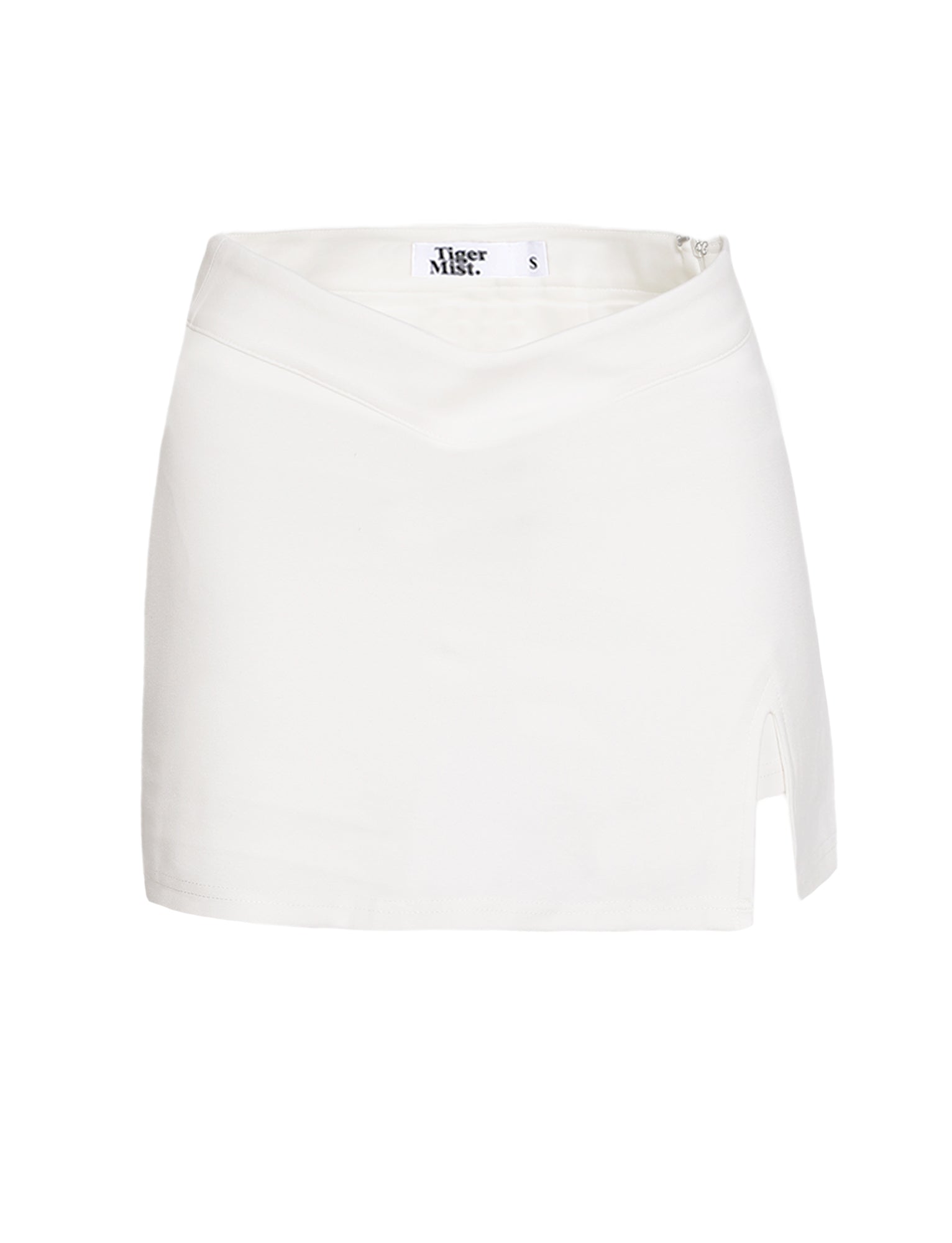 The DAPHNIE SKORT - WHITE by TIGERMIST is a mini-length skort featuring a subtle V-shaped waistband and a small slit on the right side. Made from smooth fabric, it offers a mid-rise fit and includes an internal label with "Tiger Mist" and size "S.