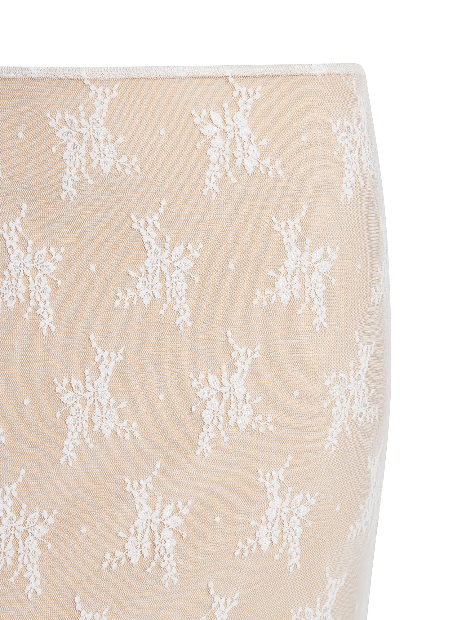 Close-up image of the KAROLINA SKIRT - WHITE from TIGERMIST, adorned with a delicate pattern of white lace floral motifs. The fabric features small white polka dots nestled between the intricate floral designs.