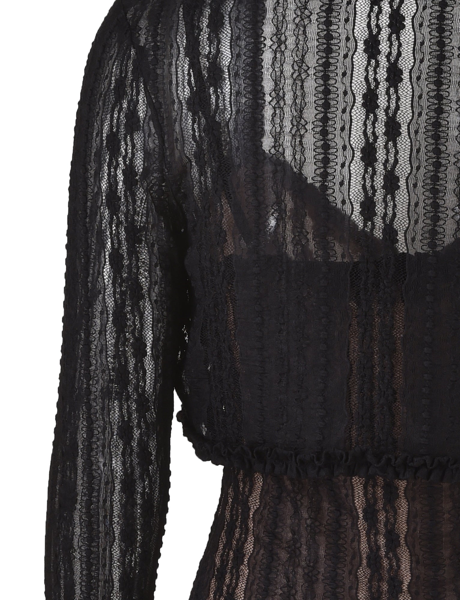 A close-up image of the upper back section of the black, long-sleeved, sheer lace SOPHA TWO PIECE DRESS by TIGERMIST. The fabric features intricate lace patterns and is slightly transparent, revealing a lighter lining underneath. The dress has a fitted look with textured lace detailing.