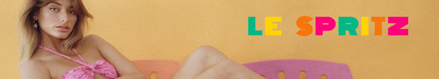 A woman in a pink halter top lounges on a pink and orange bench against a yellow background. The colorful text "LE SPRITZ" is displayed on the right side of the image.