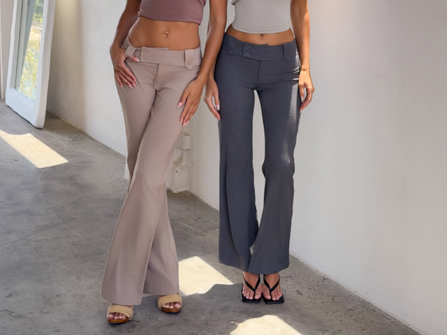 Two people standing in similar outfits holding hands posing for a photo