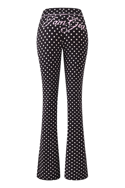 The BLARE TRACKPANT - BLACK POLKA DOT by I.AM.GIA features a polka dot print and pink cursive "Fam Gia" text on the back waistband, making it a standout piece.