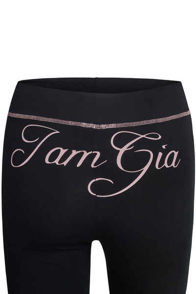 The BLARE TRACKPANT - BLACK by I.AM.GIA features large pale pink script lettering across the back, just below the waistband—offering a stylish and comfortable look true to the brand's signature style.
