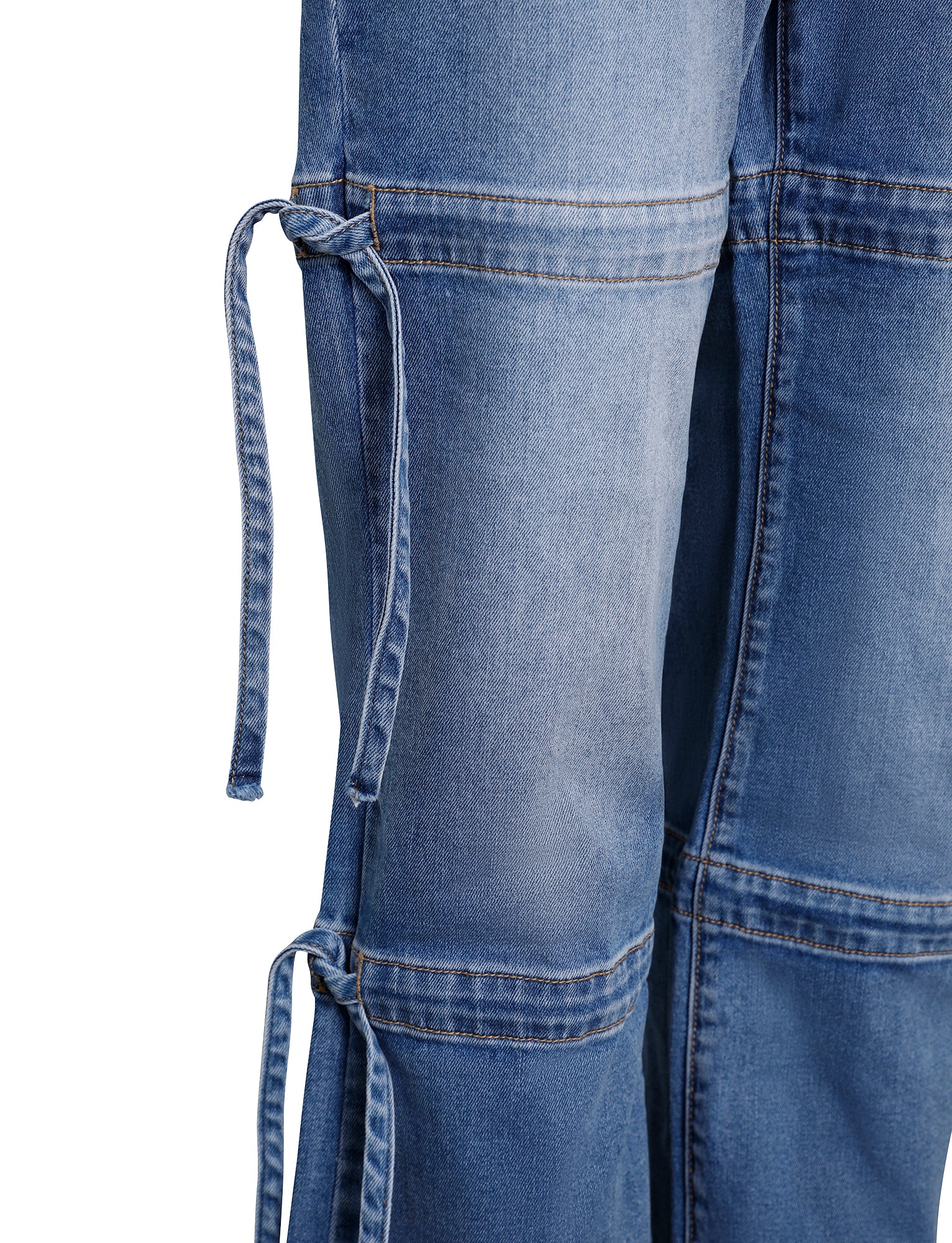 A close-up shot of the BAINES PANT - BLUE : LIGHT WASH from TIGERMIST showcases intricate seam details and decorative ties on the side. The fabric features a light wash with visible stitching and slight fading for a worn-in look.