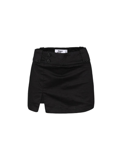 The KITTIE SKORT - BLACK by TIGERMIST is a black mini skort featuring a front slit, button accents, and an overlap waistband, shown on a white background.