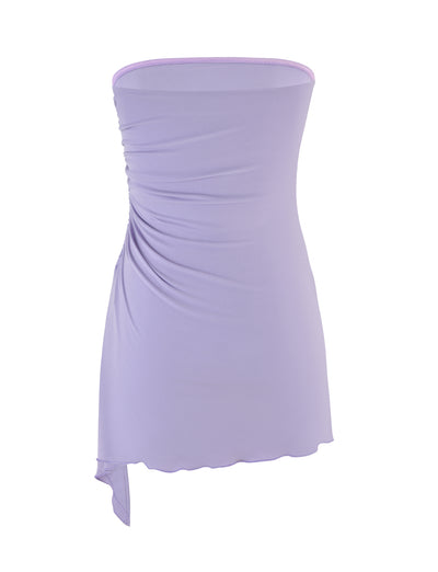 Introducing the XENIA MINI DRESS - PURPLE : LILAC from TIGERMIST, a strapless bodycon dress that captivates with its alluring lilac shade. Enhanced by a gathered pleat on the left side and an asymmetrical hemline, this dress is set against a timeless white background for added charm.