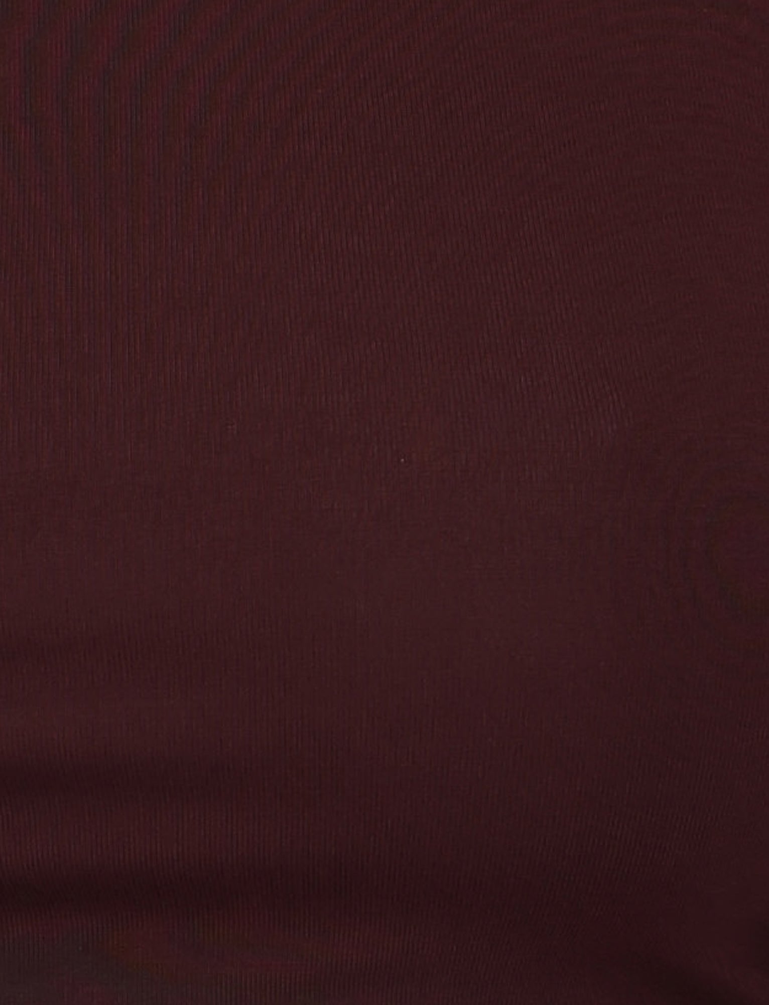 Close-up view of someone wearing a fitted, dark reddish-brown fabric in a chocolate colourway. The material appears smooth with a slight sheen, revealing subtle horizontal texture lines typical of knitted or stretch fabric, suggesting it could be the BIANKA TOP - BROWN : CHOCOLATE by TIGERMIST with its bodycon silhouette.