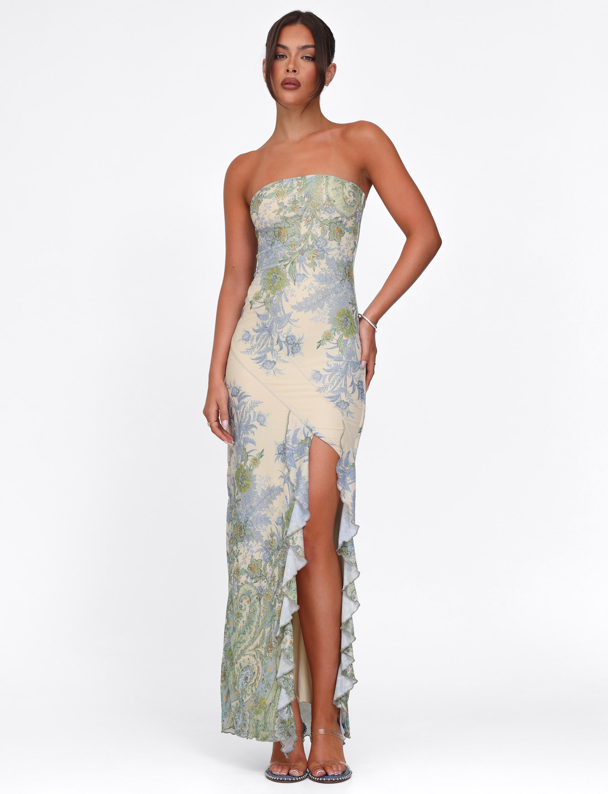 A woman wears the TIGERMIST THEO MAXI DRESS in Multi Paisley Tapestry—a strapless, form-fitting mesh bandeau dress with a ruffled thigh-high slit—posing against a plain white background.