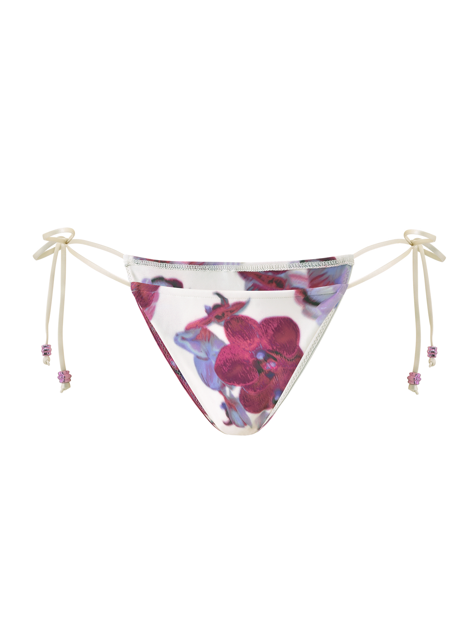 The TIGERMIST AVE BIKINI BOTTOM - ORCHID HAZE is a white bikini bottom with pink and purple floral print, featuring adjustable side ties with beaded ends.