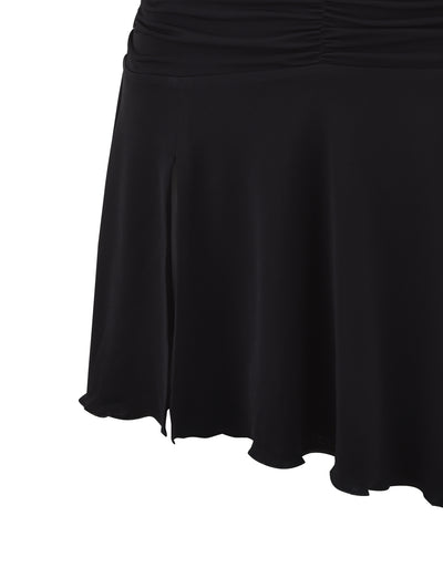 Close-up of the lower part of a black Tigermist Myra Dress. The dress appears to be made of a smooth, flowing fabric and features a small slit on the side along with subtle gathering at the waist. The hem is slightly wavy, giving a graceful and elegant look.
