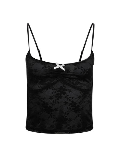 The image showcases the Rachelle Top in black from TIGERMIST, featuring delicate thin spaghetti straps. The top boasts a subtle floral lace pattern and a small white bow at the center of the neckline. With its fitted, slightly cropped design, it exudes a delicate and feminine aesthetic.