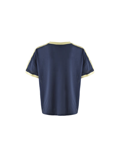 Back view of the Jayna Tee in Dusty Blue by Tigermist featuring short sleeves and light yellow trim on the neckline, sleeve edges, and shoulders. The shirt boasts a simple, plain design without any visible logos, graphics, or text.