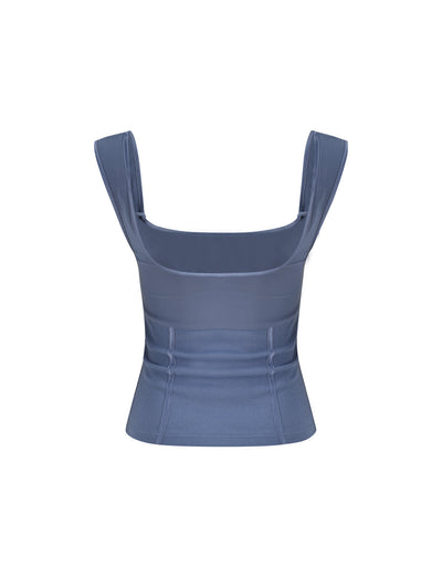 The NOEMI TOP - BLUE by TIGERMIST in Dusty Blue is a sleeveless crop top featuring wide shoulder straps and a square neckline. This stylish piece boasts a ribbed texture and fitted design, highlighting its structured look.