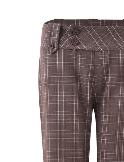 A close-up of the KITTIE PANT - BROWN : CHOCOLATE CHECK from TIGERMIST showcases a high-waisted design. The waistband features two dark buttons on a diagonal tab, while the brown plaid pattern is adorned with intersecting white and dark lines. The fabric appears tailored for a clean, structured fit.