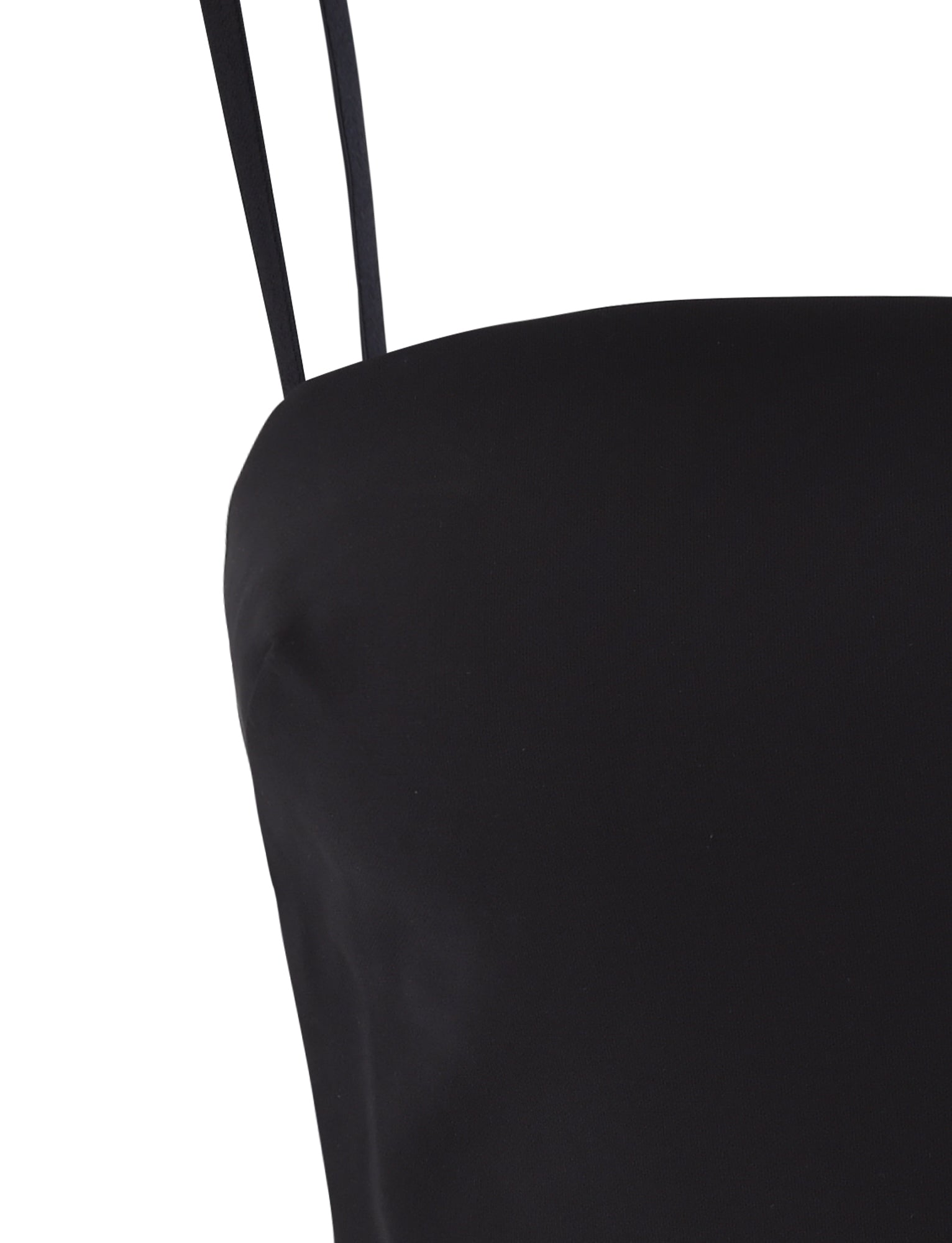 Close-up view of the NAYSHA TOP - BLACK by TIGERMIST, showcasing a smooth black sleeveless garment with thin shoulder straps, with the image focusing on the upper section of the outfit.