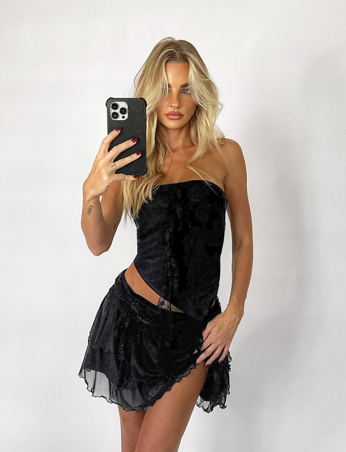 A woman in the chic Harper Top by TIGERMIST takes a stunning selfie.