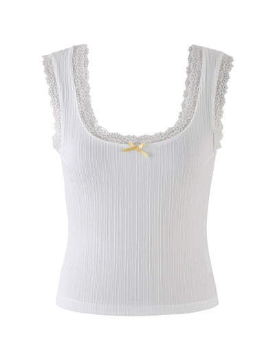 Introducing the SABINE TOP - WHITE by TIGERMIST: A sophisticated sleeveless white ribbed tank top, beautifully accentuated with lace trim around the scoop neckline and shoulders. Below the neckline, a delicate light yellow ribbon bow adds a touch of charm. The vertically ribbed fabric texture enhances its subtle elegance.