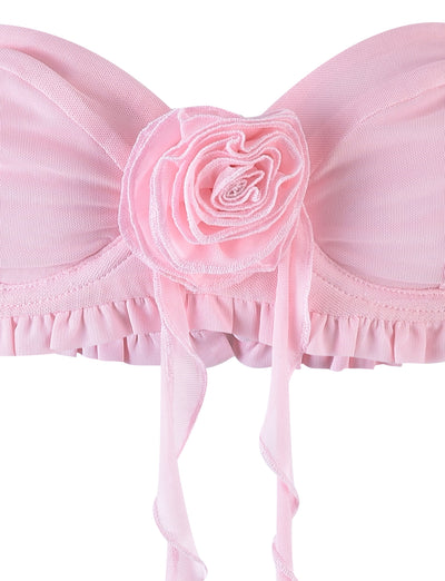 Close-up of the HEAVEN TOP - PINK by TIGERMIST, showcasing a decorative fabric rose at the center. This bandeau top is detailed with ruched fabric and a frilled trim along the bottom, complemented by ribbon-like straps that hang down from the flower.