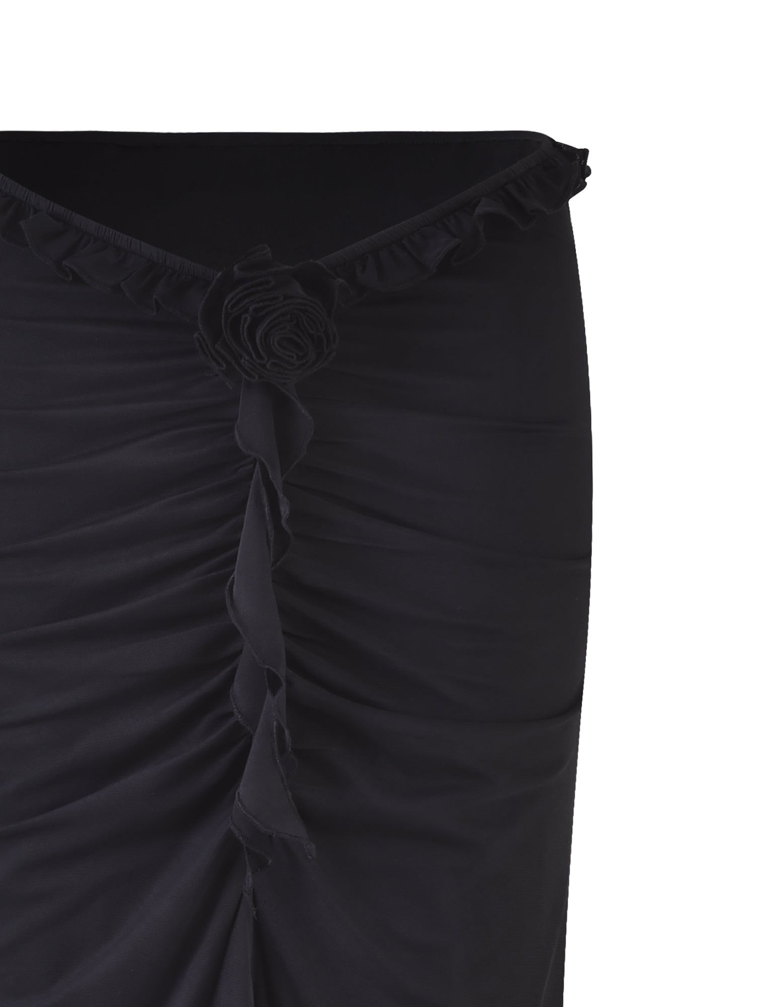 Image of the HEAVEN MAXI SKIRT - BLACK by TIGERMIST, with a close-up focus on a gathered section at the top, adorned with a ruffled edge and a decorative fabric rose in the center. The fabric appears textured and slightly ruched, suggesting a form-fitting design.