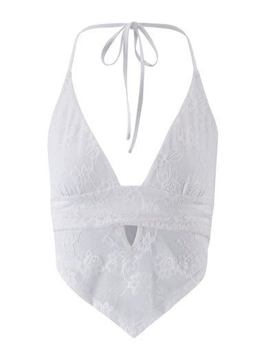 The Faye Lace Top in white from TigerMist features a halter design with spaghetti straps that tie at the neck. This lace top boasts a deep V neckline, a keyhole cutout below the bust, and intricate floral lace patterns throughout. The hemline comes to a point, creating an elegant handkerchief-style finish.