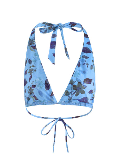 The STACI BIKINI TOP - BLUE : WATERCOLOUR by TIGERMIST is a blue floral bikini top with a halter neck design. It features adjustable ties at the back of the neck and mid-back for a secure fit. The fabric is adorned with a pattern of various flowers and leaves in different shades of blue and purple.