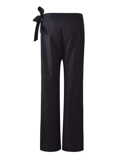 The TRISTAN PANT - BLACK from TIGERMIST is displayed against a white background. These trousers feature a high waist with a tied bow on the left side and have a straight-leg design, offering a classic and elegant look.