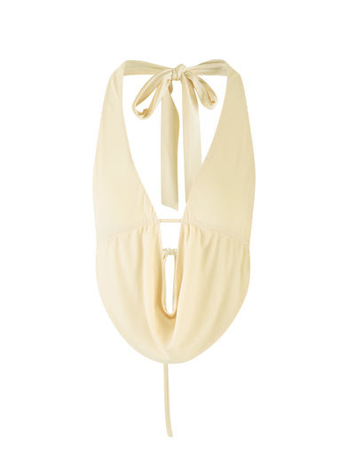 The PEARL TOP in a Pale Lemon Butter hue from TIGERMIST is a yellow, halter-style sleeveless top with a plunging neckline. It ties at the back of the neck and showcases an open back with a drawstring detail at the lower back. The fabric seems lightweight and flowy.